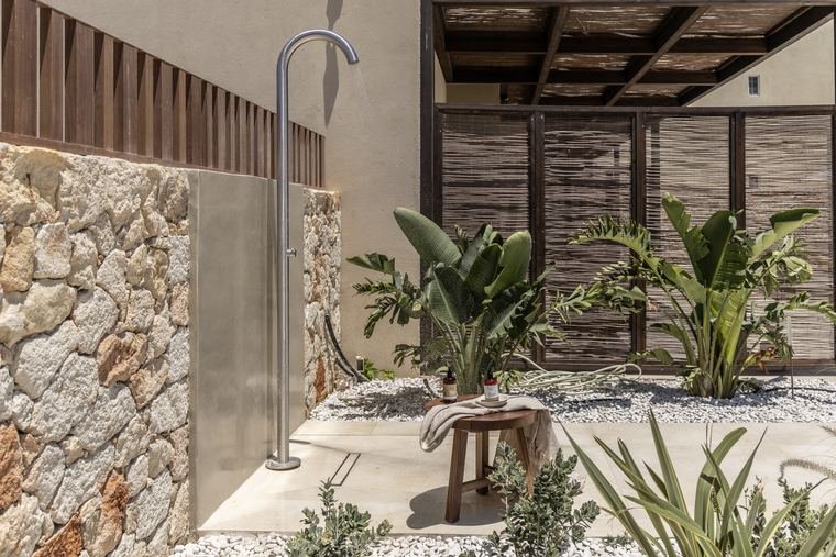 The outdoor shower against the stone wall